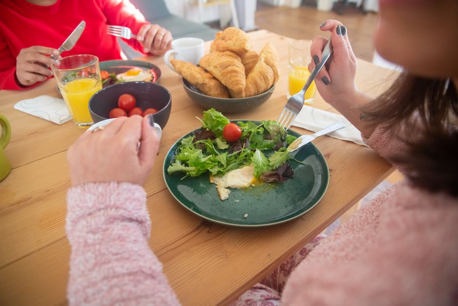 Cozy breakfast scene with fresh salad, croissants, and juice, perfect for a healthy morning.