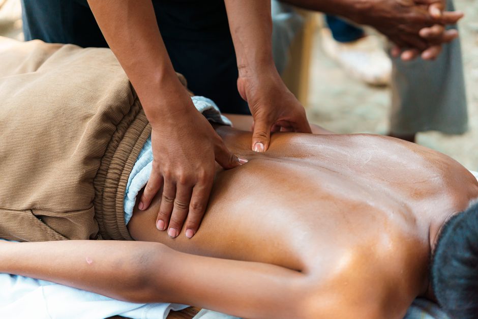 An outdoor massage session capturing the soothing techniques of a back massage, promoting relaxation and wellness.